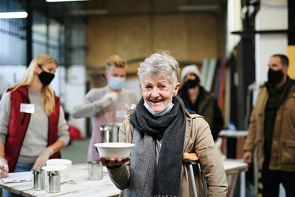 Volunteers_serving_hot_soup_for_homeless_in_community_charity_donation_center__coronavirus_concept.jpeg  